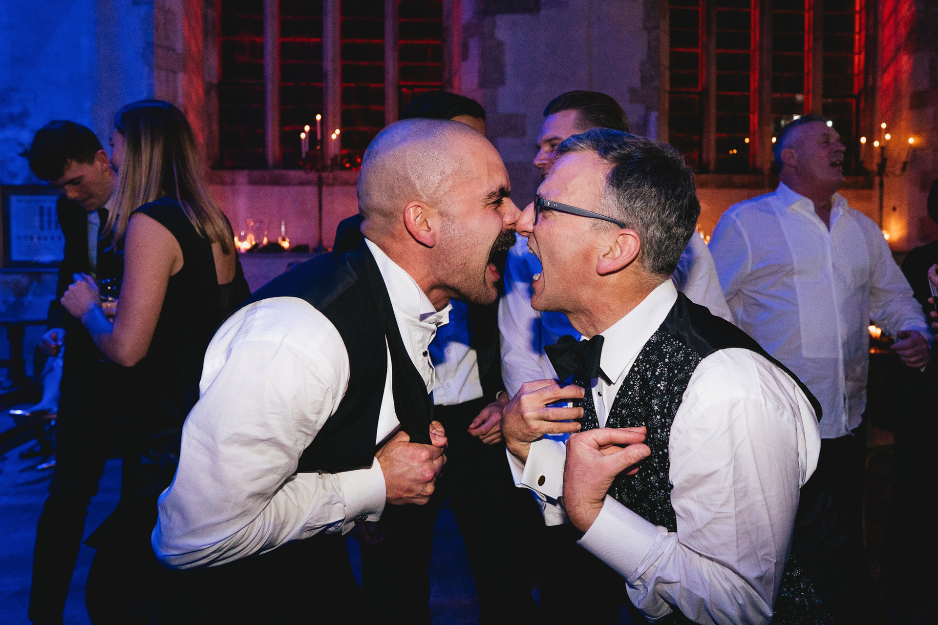 Wedding guests singing face to face with each other on the dancefloor during a winter wedding at Dartington Hall in Devon