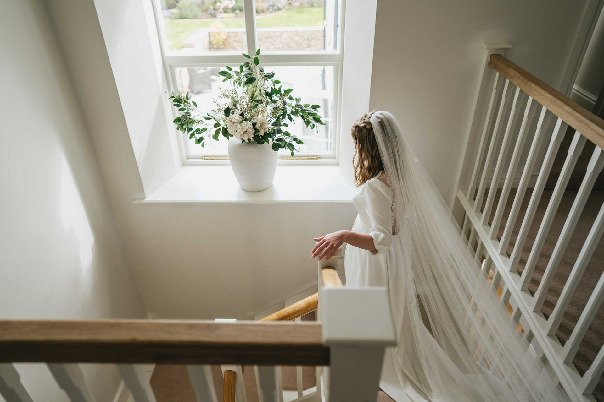 A bride walking down the stairs for her Devon wedding ceremony