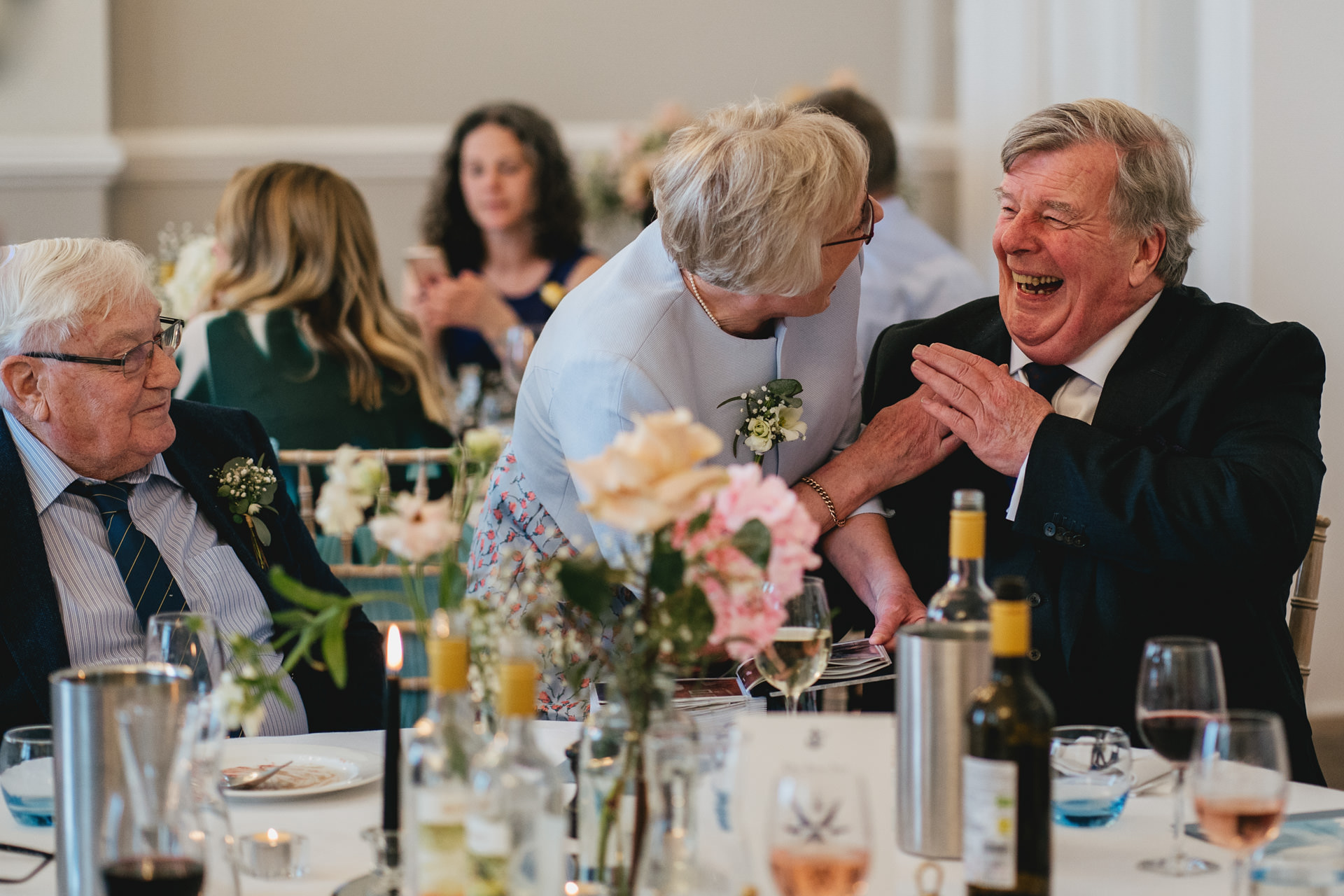 Wedding guests laughing together during the meal