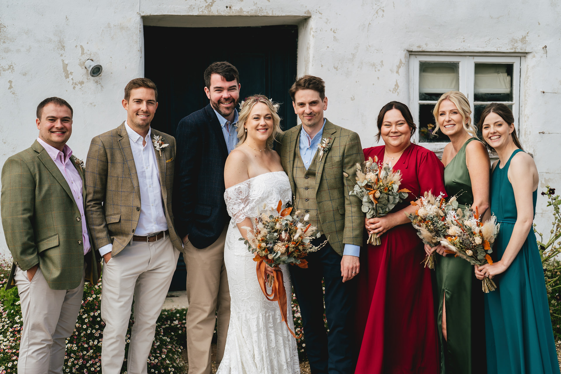 Bride and groom with wedding party group photo outside River Cottage during their Devon wedding day