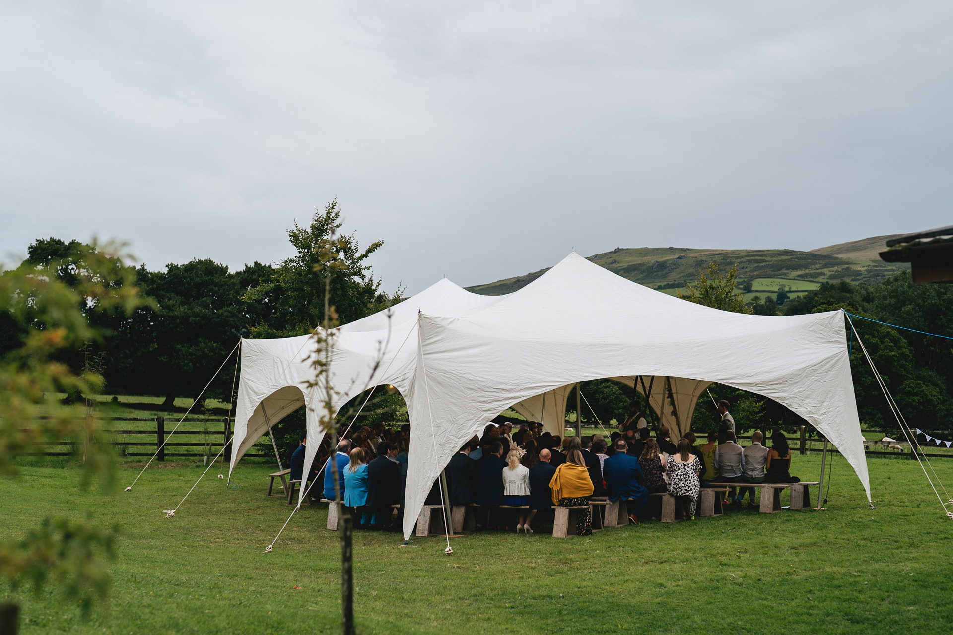 A wedding ceremony at a village hall with a stretch tent outside and views of Dartmoor behind
