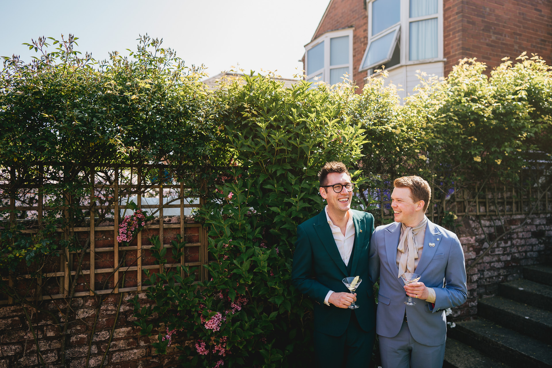 Grooms laughing together at home in Exeter before an elopement wedding