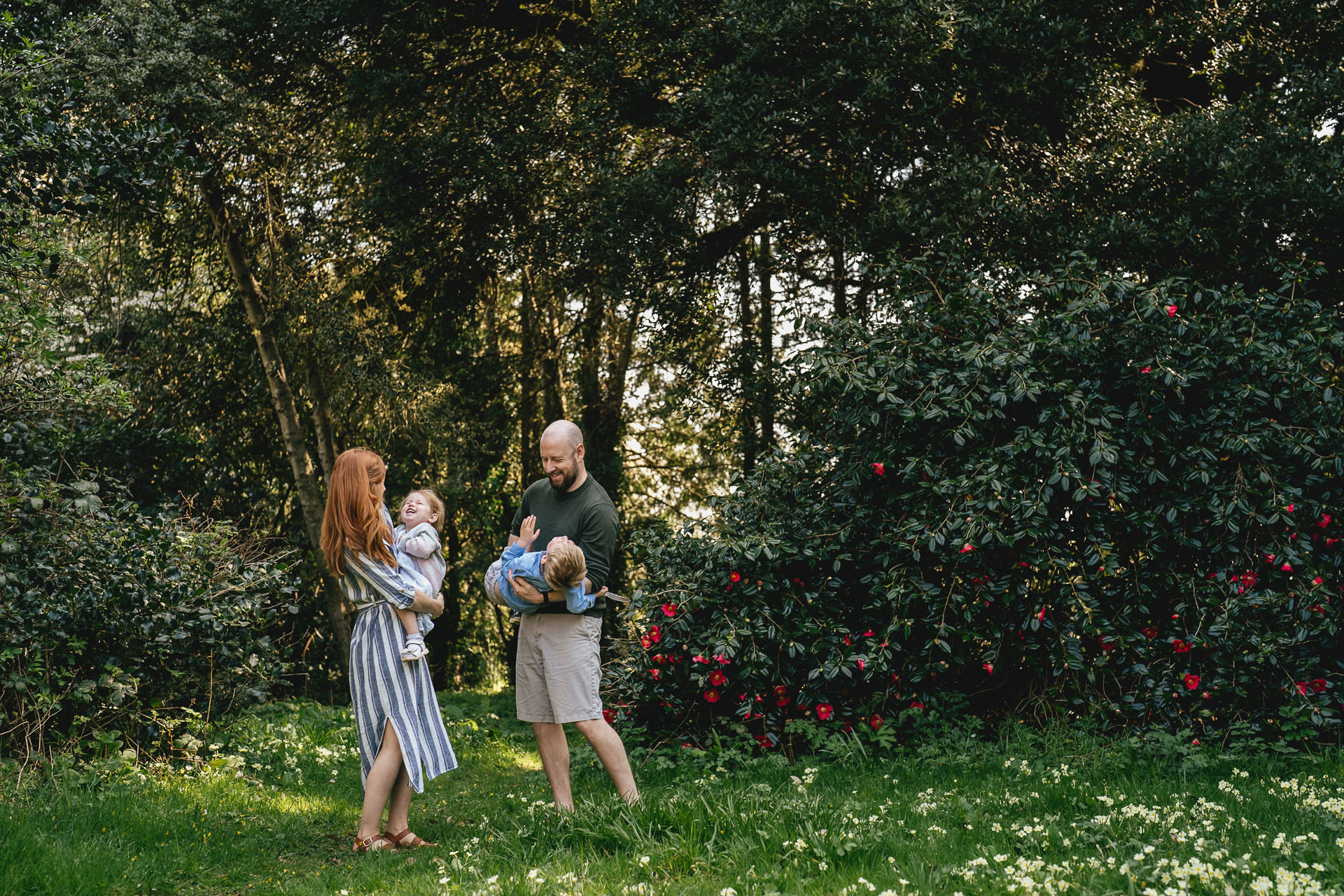 Two parents playing with two children during a family photo session near Exeter