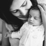 Newborn photography session images of a mother at home with her baby