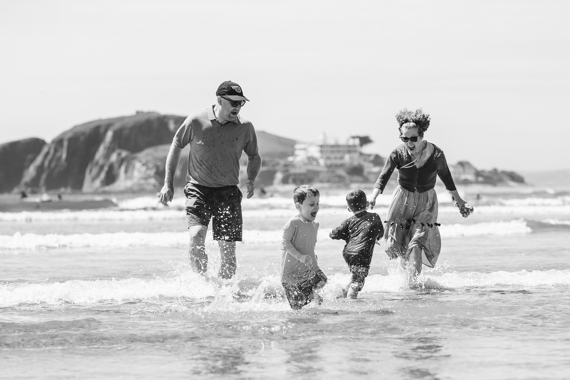 Parents playing with two children in the water at Bigbury on Sea in Devon