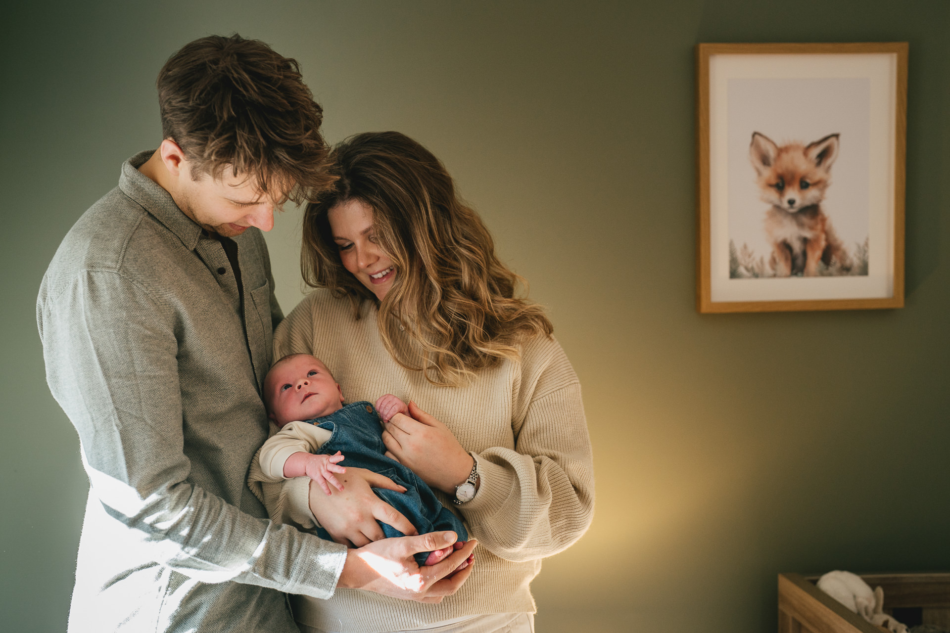 Parents cuddling a young baby during a newborn photo session in Devon