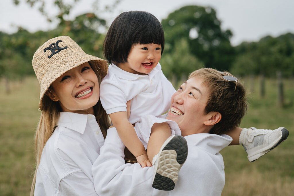 Parents playing with a young toddler girl during a family photography session at the Newt in Somerset