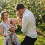 A family playing together in the garden and laughing during a family photography session