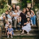 Relaxed family group photo with grandparents sitting on steps with lots of grandchildren from an extended family photography session at Symondsbury in Dorset