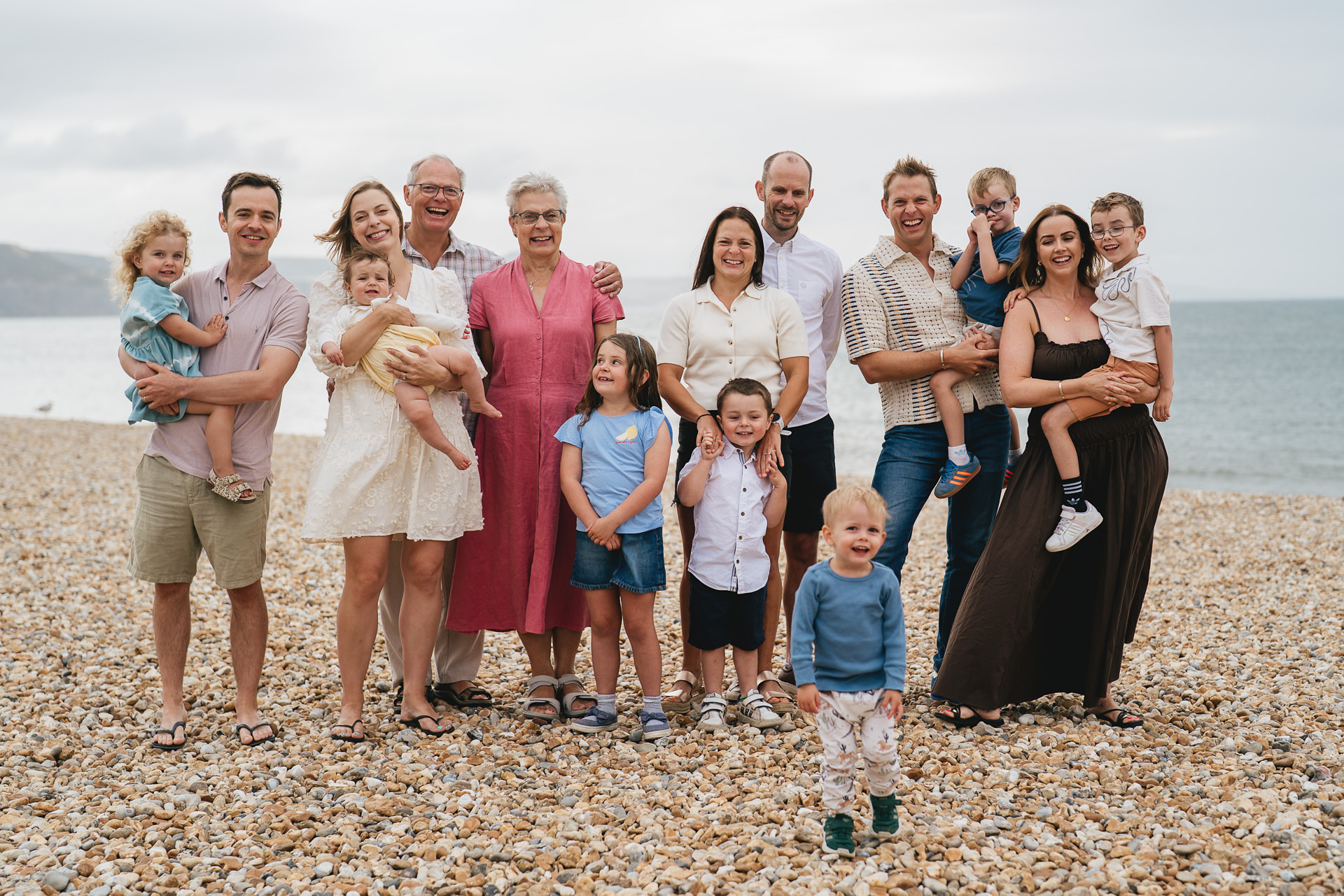 A large extended family group photo on the beach at Lyme Regis in Dorset