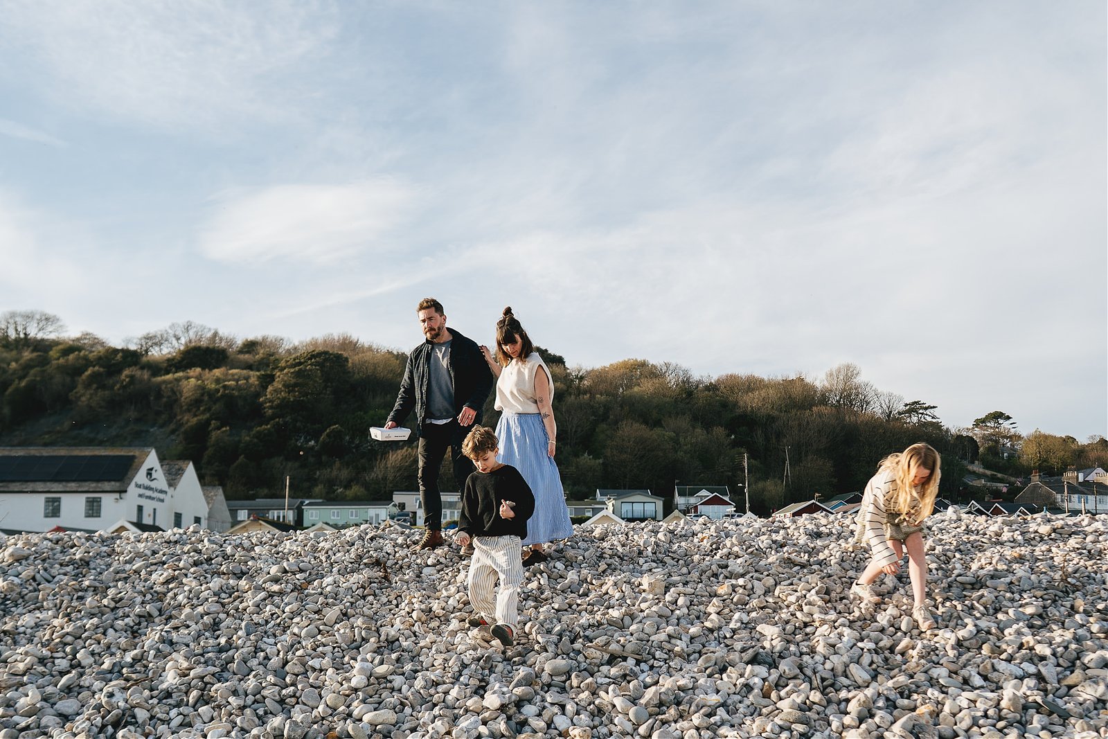 A family walking across Monmouth beach during a family photo session 