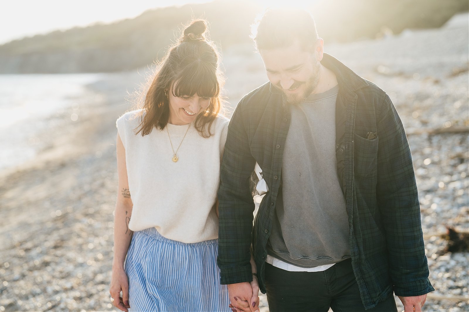 A couple walking across Monmouth beach during a family photo session with Helen Lisk Photography