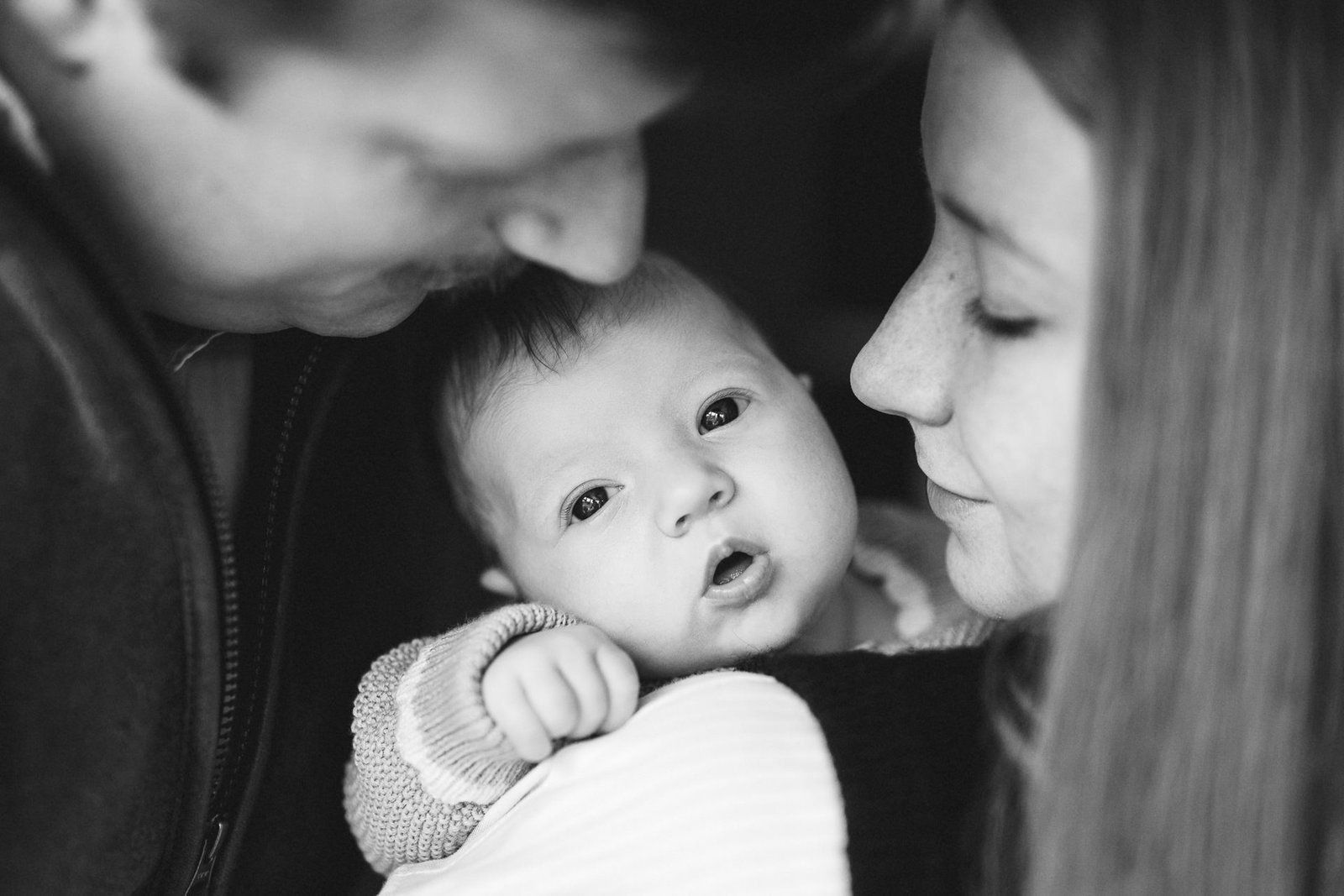 Parents cuddling a newborn baby during a photo session in Somerset