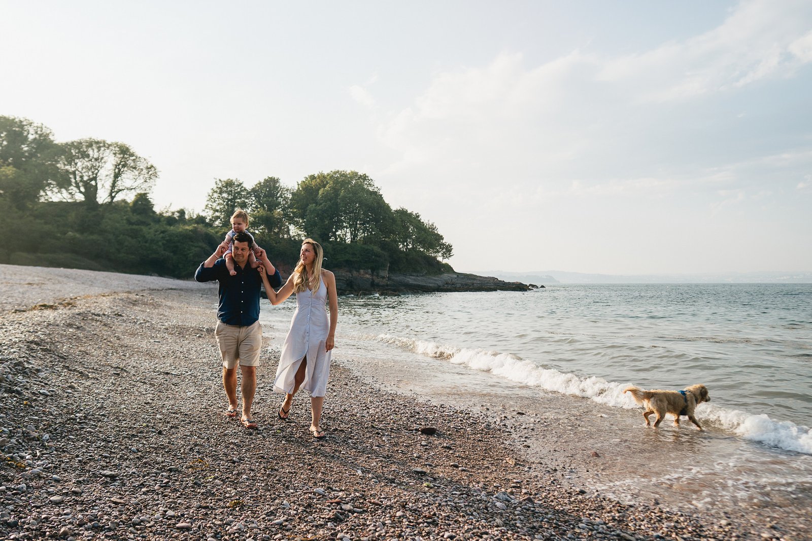 A family walking along Elberry beach during a photo session in Torbay