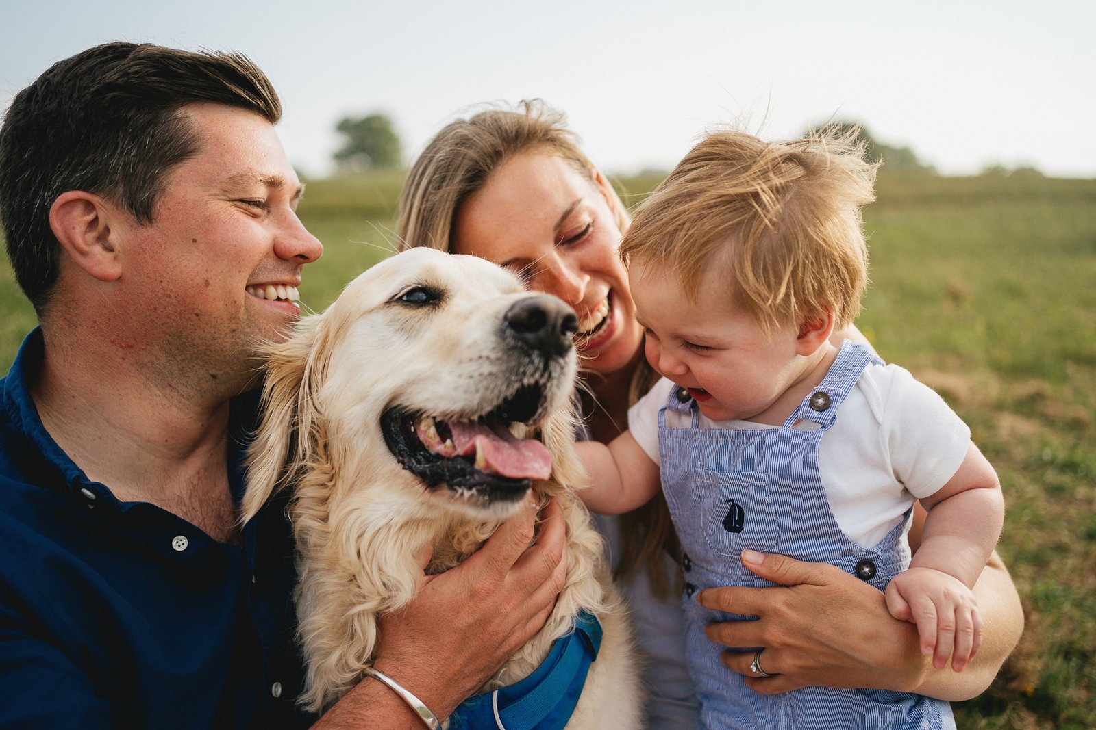 A family with their dog, laughing together during a family photo session in Torbay, Devon